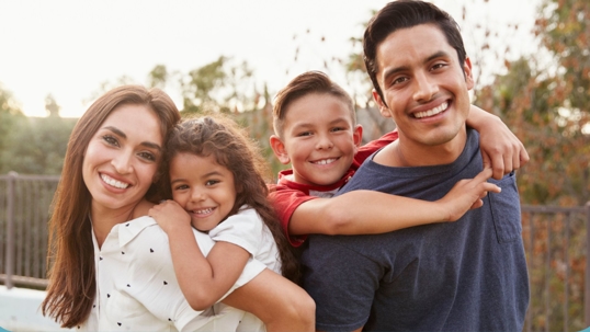 Happy family of four smiling.