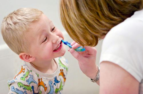 Mom brushing son's teeth